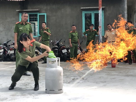 Cán bộ, chiến sĩ Công an huyện Buôn Đôn thực hành sử dụng khăn để dập tắt bình gas đang cháy.  Ảnh: Hiếu Hải