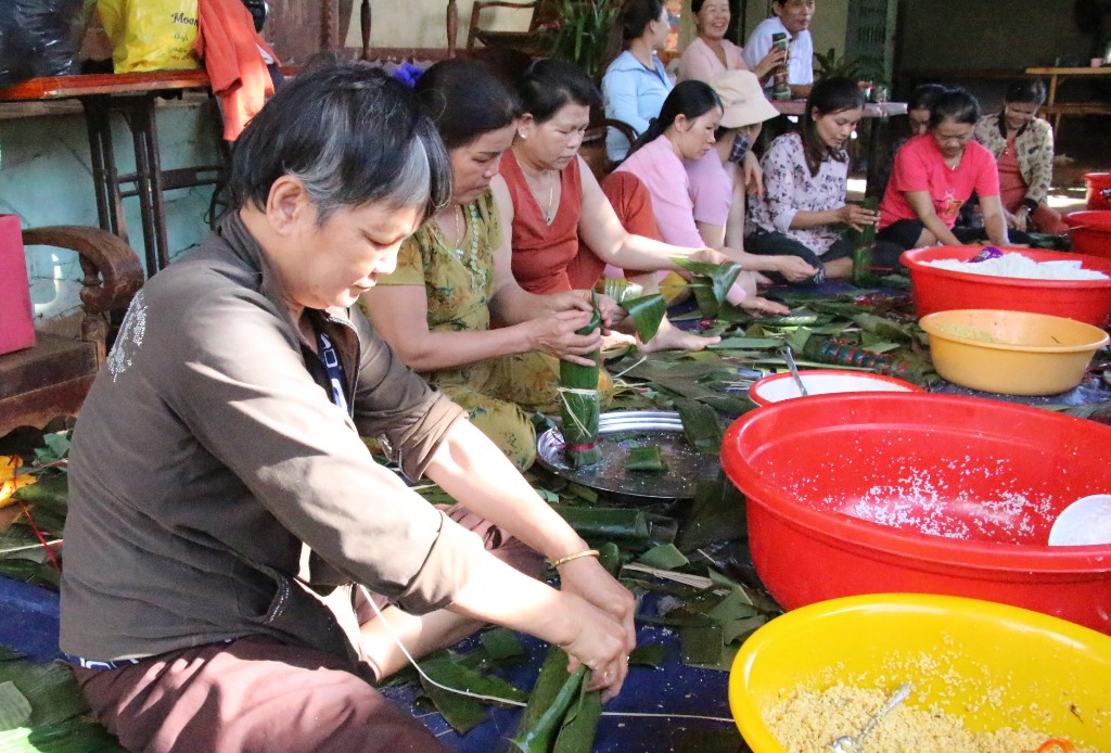 Các bà, các chị tập trung gói bánh