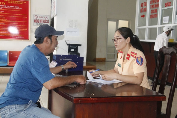 Cán bộ Phòng CSGT Công an tỉnh hướng dẫn người dân kê khai các thông tin về đổi biển kiểm soát xe kinh doanh vận tải.