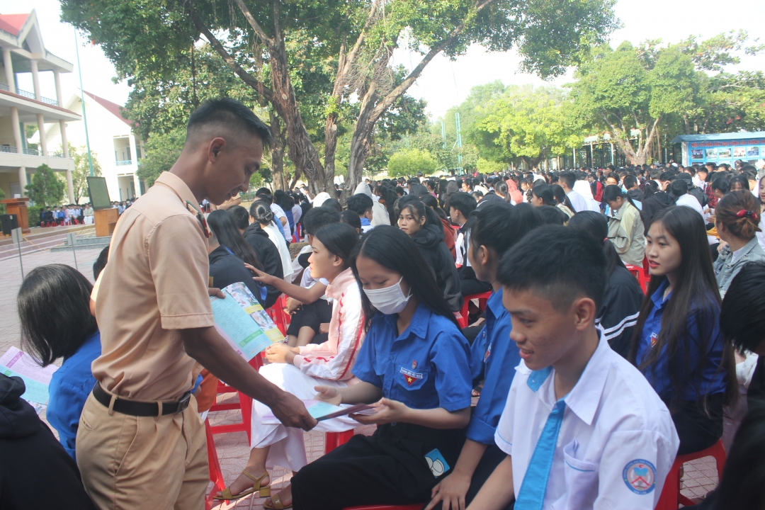 Phát tờ rơi tuyên truyền về an toàn giao thông cho học sinh Trường THPT Buôn Đôn. Ảnh: Q.An