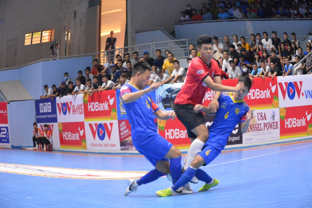 Cầu thủ chủ nhà áo đỏ Hưng Gia Khang Đắk Lắk tỏng vòng vây của các cầu thủ đội khách.