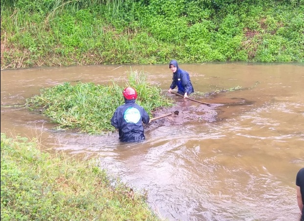 Cán bộ quản lý công trình và người dân khu vực hồ đội C36 (xã Ea Riêng) khơi thông dòng chảy thoát nước.