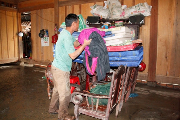 Anh Thào Kháy Man (thôn 9, xã Cư San) dọn dẹp lại đồ dùng sau khi nước rút.
