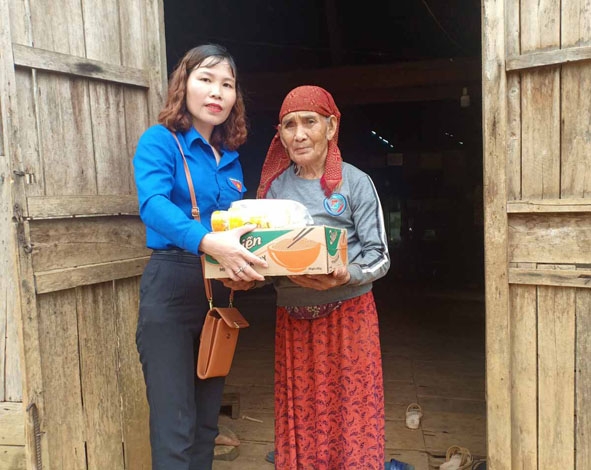 Chị Hòa  Thị Hằng tặng nhu  yếu phẩm cho người nghèo  ở buôn Drai (xã Ea Na). 