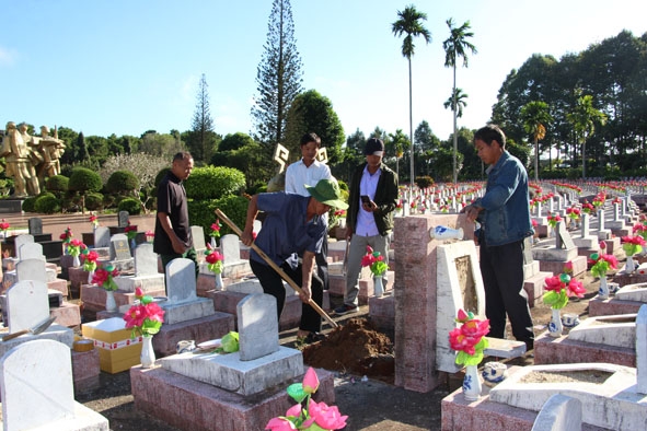 án bộ quản trang cùng thân nhân, đồng đội  hỗ trợ  cất bốc  hài cốt  liệt sĩ Bạch Văn Ao. 