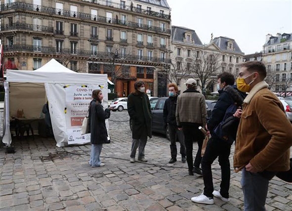 Người dân xếp hàng chờ lấy mẫu xét nghiệm Covid-19 tại Paris (Pháp).  