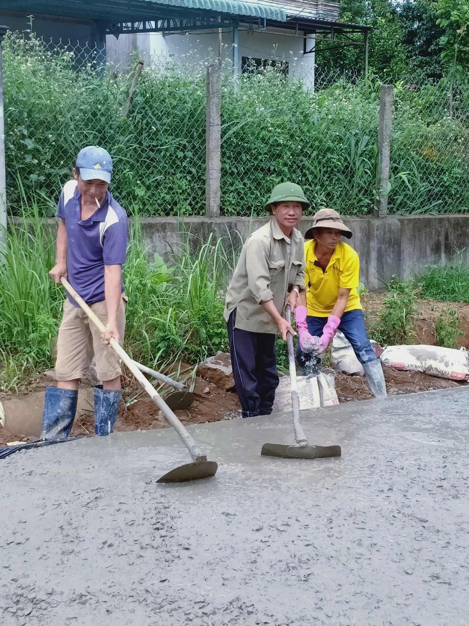 Anh Nguyễn Thế Hoan (giữa) cùng người dân làm đường giao thông nông thôn.   