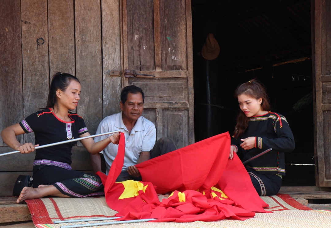 Chị H’Băm Kbuôn (bên phải) cùng người dân buôn Trăp tham gia làm cờ.