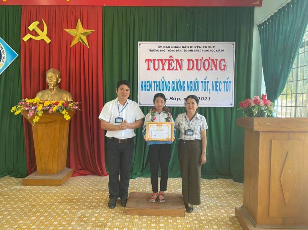 Hiệu trưởng Trường PTDTNT THCS Ea Súp (bên trái) tuyên dương em Hoàng Thị Xuân Loàn về hành động đẹp