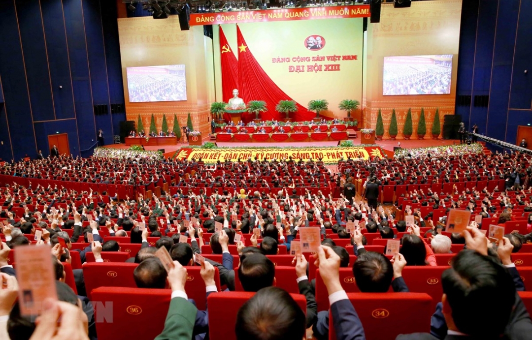 Các đại biểu biểu quyết thông qua Nghị quyết Đại hội XIII của Đảng.  Ảnh: TTXVN