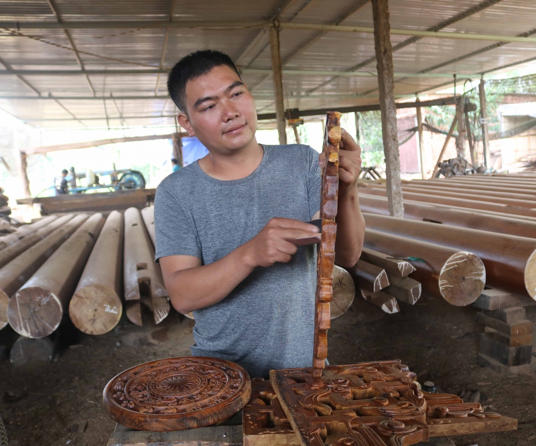 Anh Nguyễn Văn Sơn đang  chỉnh sửa lại hoa văn trên gỗ. 