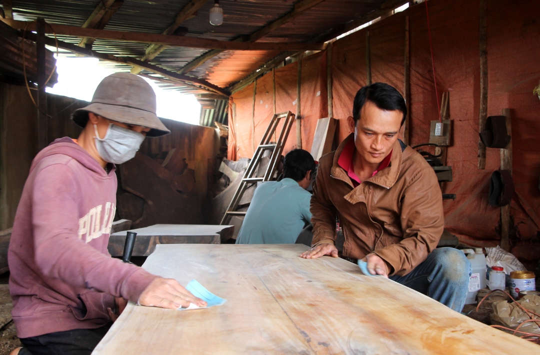 Anh Lê Nguyễn Nguyên (bên phải) cùng các thành viên Nhóm thiện nguyện  Vinh Quang hoàn thiện các sản phẩm đồ gỗ bán lấy tiền thực hiện hoạt động thiện nguyện. 