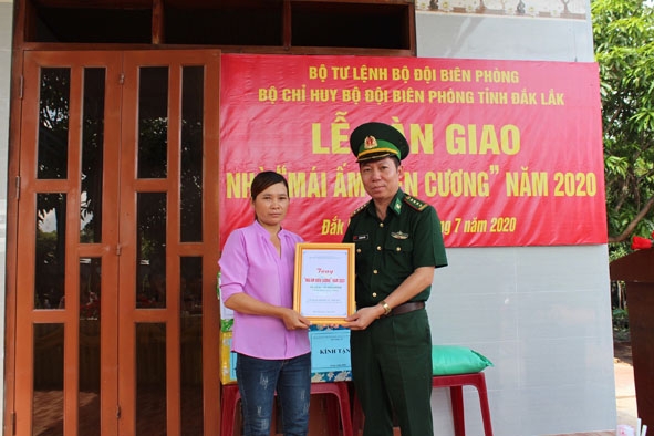 Đại tá Đỗ Quang Thấm, Phó Chính ủy Bộ Chỉ huy BĐBP tỉnh trao Quyết định trao tặng nhà Mái ấm biên cương cho chị Lữ Thị Sót (xã Ia Lốp, huyện Ea Súp).