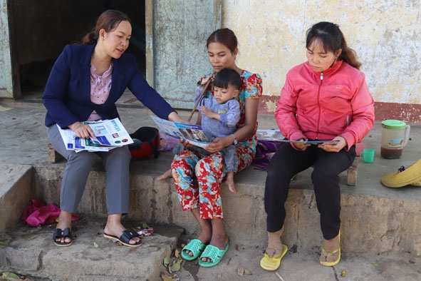 Chị H’Nanh Byă(bìa trái) tuyên truyền, hướng dẫn các biện pháp phòng dịch bệnh cho bà con.