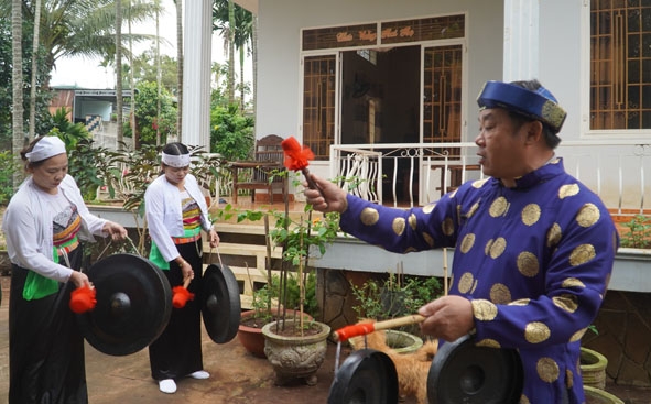 Ông Nguyễn Văn Phú hướng dẫn học viên nữ cách cầm dùi đánh chiêng.  