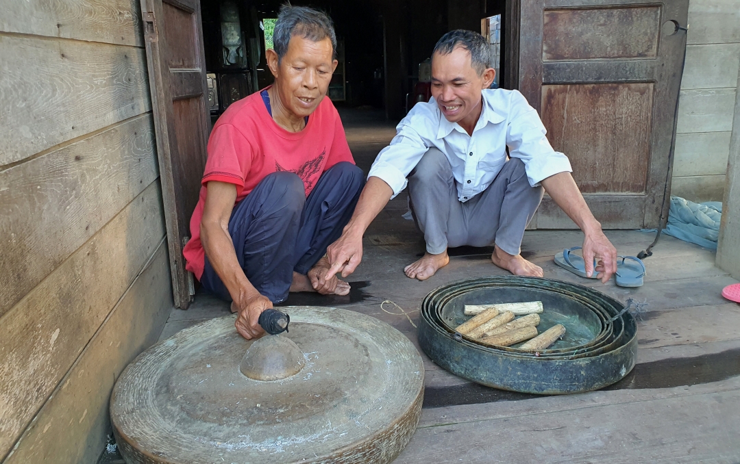 Ama Biên (bên trái) biết đánh chiêng từ nhỏ, hiện gia đình ông vẫn giữ được  bộ cồng chiêng. 