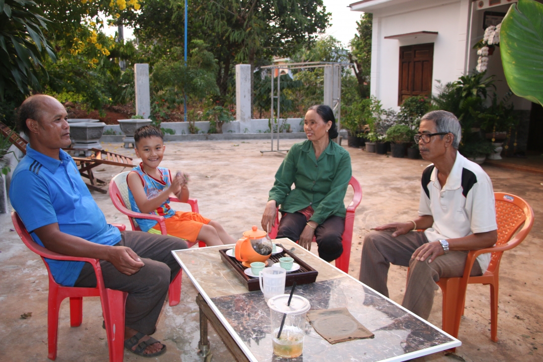 Ông Y Tuyên Bkrông, Trưởng buôn Drai H’ling (bìa trái) thăm hỏi đời sống người dân trong buôn.  