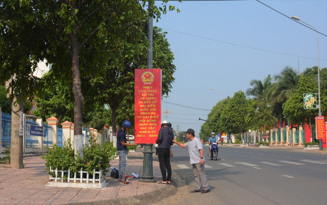 Cán bộ Phòng Văn hóa - Thông tin huyện treo băng rôn, khẩu hiệu tuyên truyền về công tác bầu cử trên tuyến đường trung tâm huyện. 