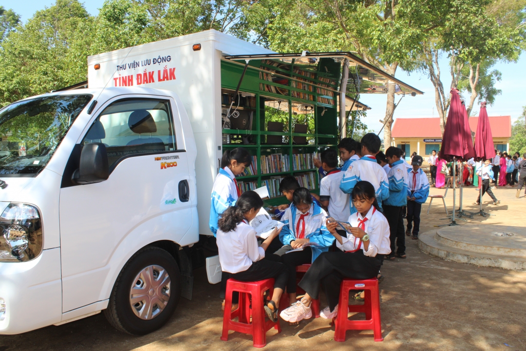 Học sinh Trường THCS Ea Tul (xã Ea Tul, huyện Cư M'gar) chăm chú đọc sách từ xe Thư viện lưu động (Thư viện tỉnh).