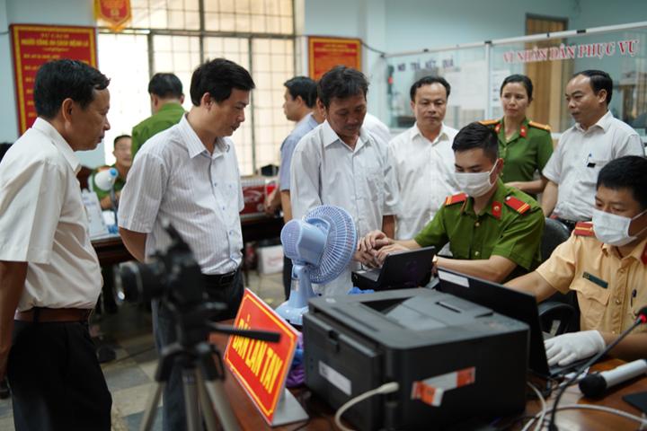 Bí thư Huyện ủy Trần Hồng Tiến (thứ 2 bên trái ảnh) kiểm tra công tác kiểm tra việc thu nhận hồ sơ căn cước công dân tại Công an TT Phước An