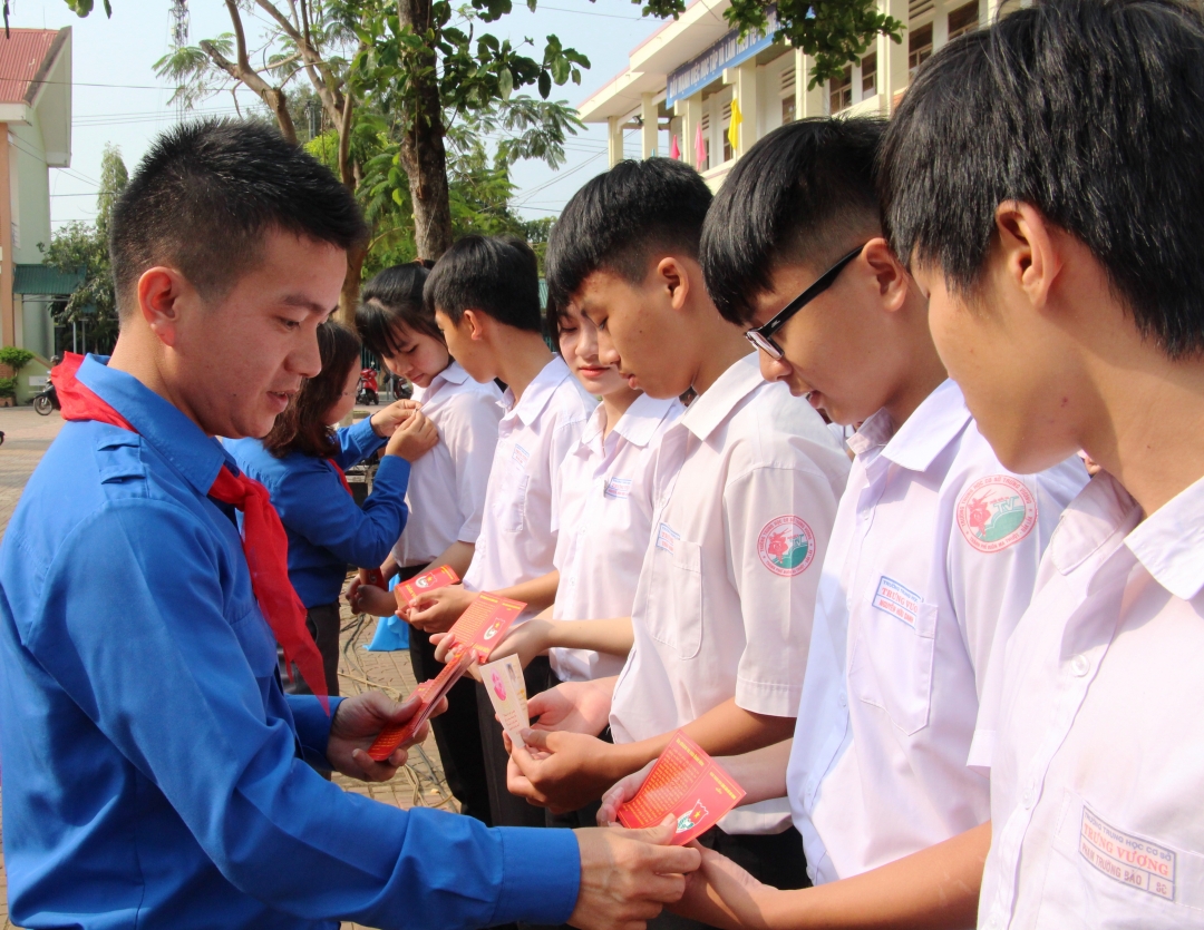 Chủ tịch Hội đồng Đội tỉnh Trần Doãn Tới trao thẻ Đoàn cho đoàn viên mới của Trường THCS Trưng Vương. 