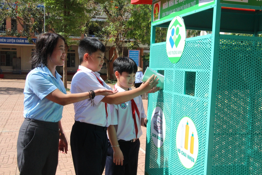 Giáo viên Tổng phụ trách Đội Liên đội Trường Tiểu học Lê Thị Hồng Gấm hướng dẫn học sinh  phân loại giấy vụn, chai nhựa.  