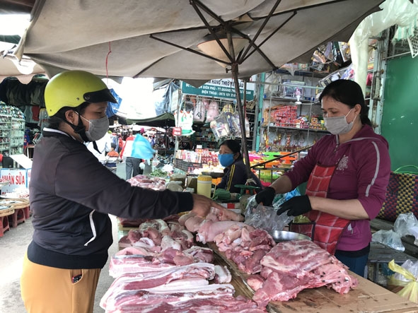Người dân và tiểu thương ở chợ Trung tâm thị trấn Quảng Phú thực hiện nghiêm việc mang khẩu trang khi đến chợ. 