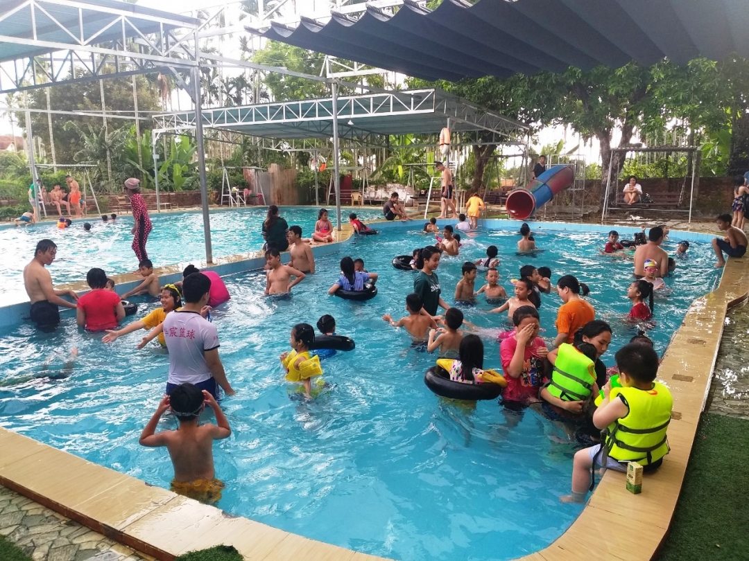 Khá đông trẻ em và người lớn tham gia bơi lội tại một hồ bơi trên đường Giải Phóng (phường Tân Thành, TP. Buôn Ma Thuột) vào mùa hè. 