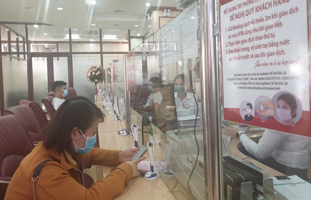 Khách hàng và cán bộ Agribank Đắk Lắk đeo khẩu trang nghiêm túc khi thực hiện giao dịch