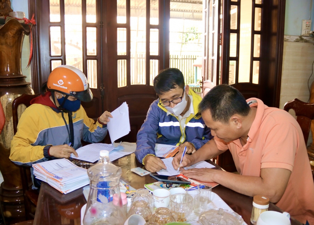 Nhân viên Bưu điện huyện Krông Năng hướng dẫn người dân xác nhận thông tin và ký nhận thẻ căn cước công dân.