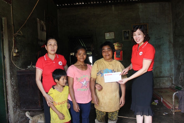 Bà Nguyễn Thị Lý, Phó Chủ tịch Hội Chữ thập đỏ TP. Buôn Ma Thuột (bìa phải) trao tiền hỗ trợ cho gia đình chị H’Việt Adrơng (xã Ea Tu).  
