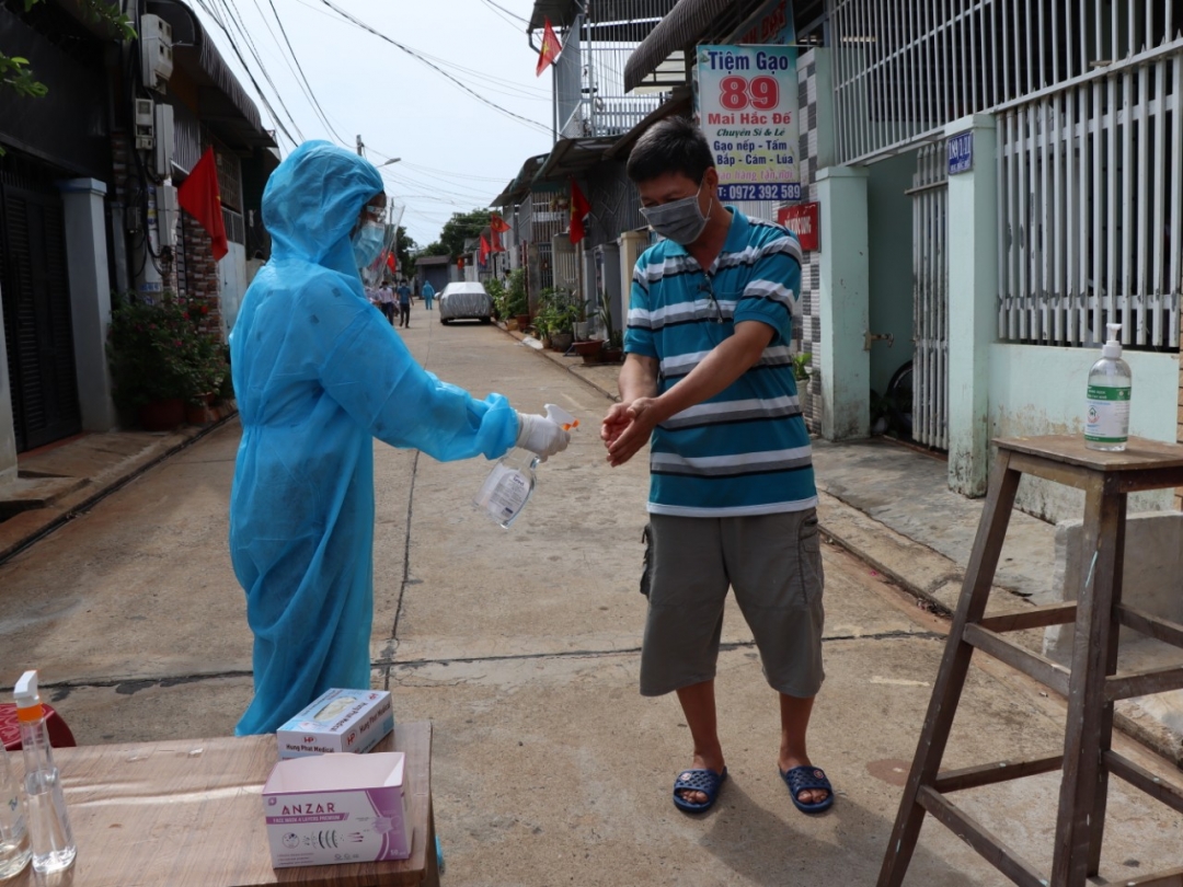 Các cử tri khu vực phong tỏa hẻm 189/1 Mai Hắc Đế được cán bộ y tế hướng dẫn sát khuẩn tay và đeo găng tay y tế trước khi tham gia bầu cử.