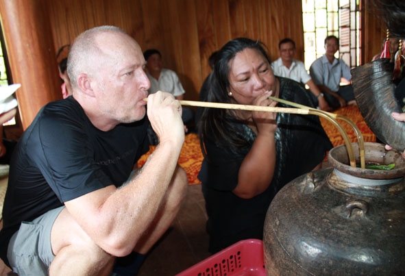 Du khách trải nghiệm văn hóa rượu cần tại một hộ gia đình làm du lịch cộng đồng ở buôn Akô Dhông. 