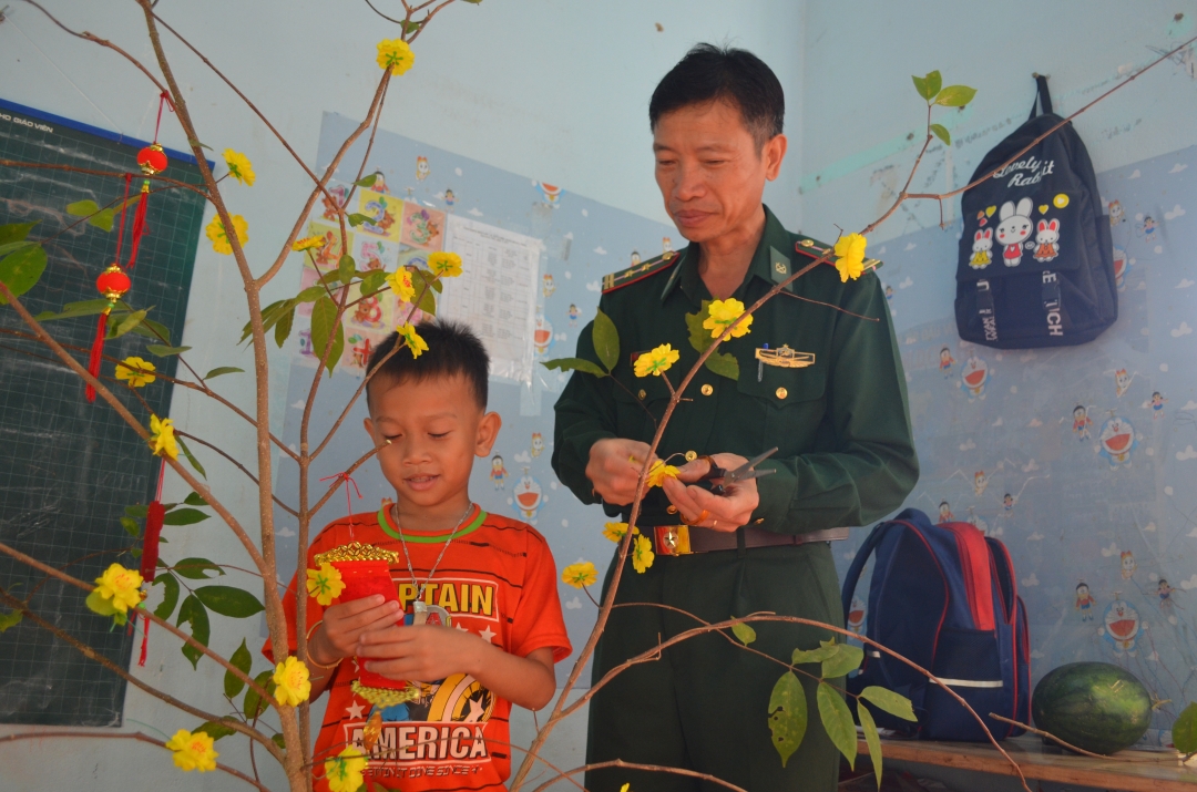 Em Y Phú Mlô bên cha nuôi biên phòng Đỗ Văn Nhương.