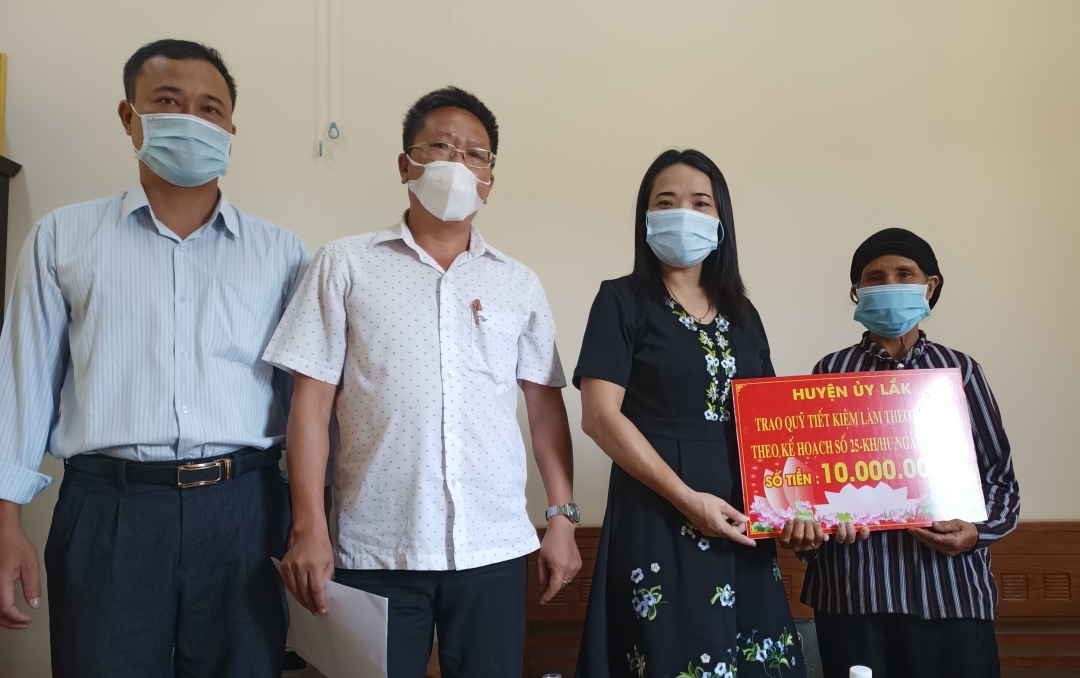 Phó Bí thư Thường trực Huyện ủy Đào Thị Thanh An trao tiền hỗ trợ cho đồng chí  Siu Som (Đảng bộ xã Yang Tao).