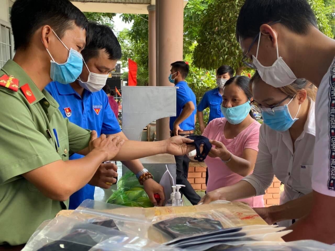 Đoàn viên thanh niên Công an huyện Cư M'gar phát khẩu trang cho người dân đến làm thẻ căn cước cồn
