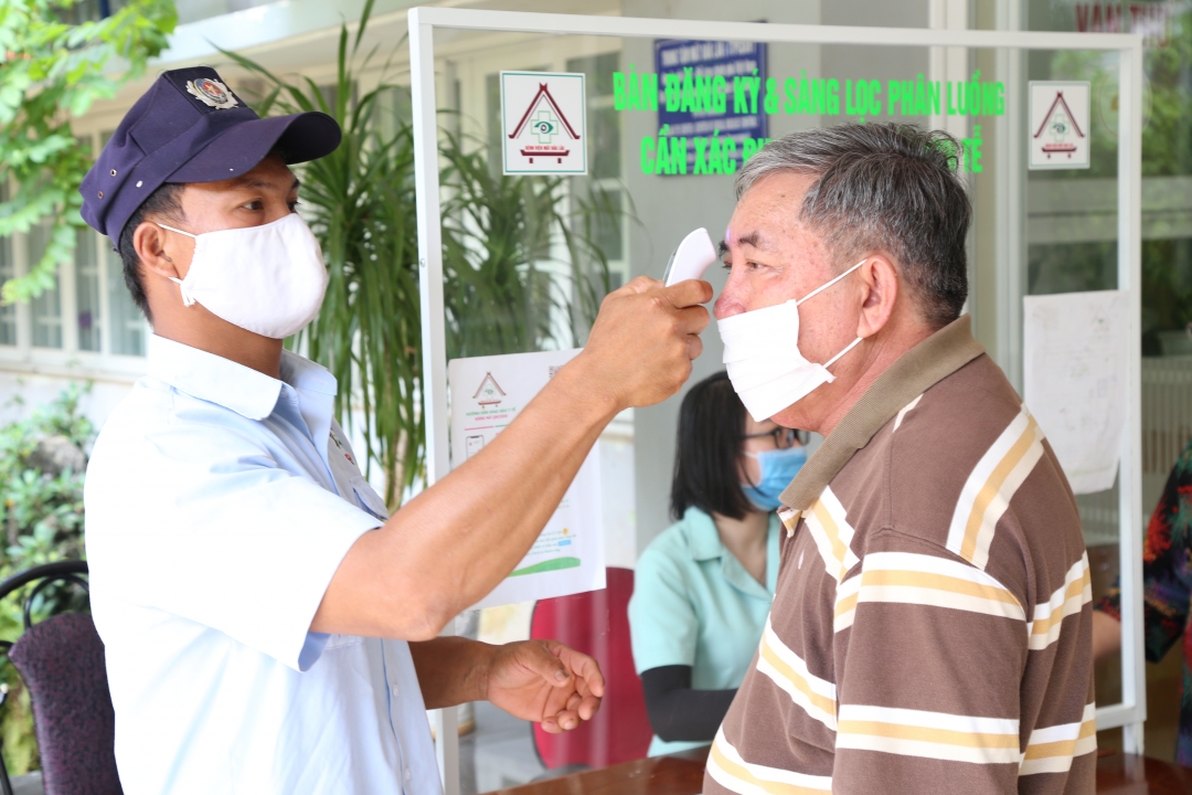 Người dân được đo thân nhiệt trước khi vào thăm khám bệnh tại Bệnh viện Mắt Đắk Lắk. Ảnh: Đình Thi