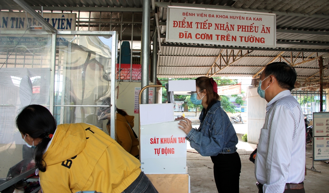 Giám đốc Trung tâm Y tế huyện Ea Kar Đỗ Xuân Lộc (bìa phải) kiểm tra việc thực hiện công tác phân luồng,  khai báo y tế tại khu vực ra vào của trung tâm. Ảnh: N. Xuân