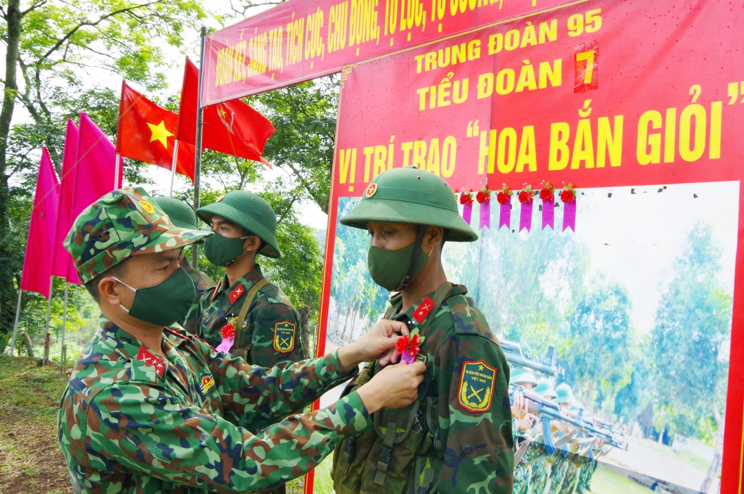 Chiến sĩ mới có thành tích tốt trong đợt kiểm tra được chỉ huy đơn vị gắn hoa bắn giỏi.