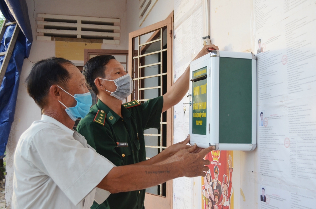 Cán bộ Đồn Biên phòng Ia Rvê, BĐBP Đắk Lắk cùng người dân lắp đặt hòm thư tố giác tội phạm và tố giác hành vi xuất, nhập cảnh trái phép. 