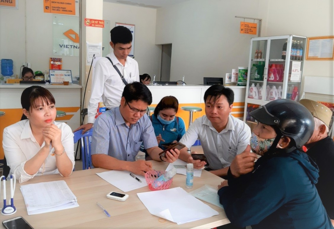 Cán bộ BHXH huyện hướng dẫn người dân cài đặt ứng dụng VssID.