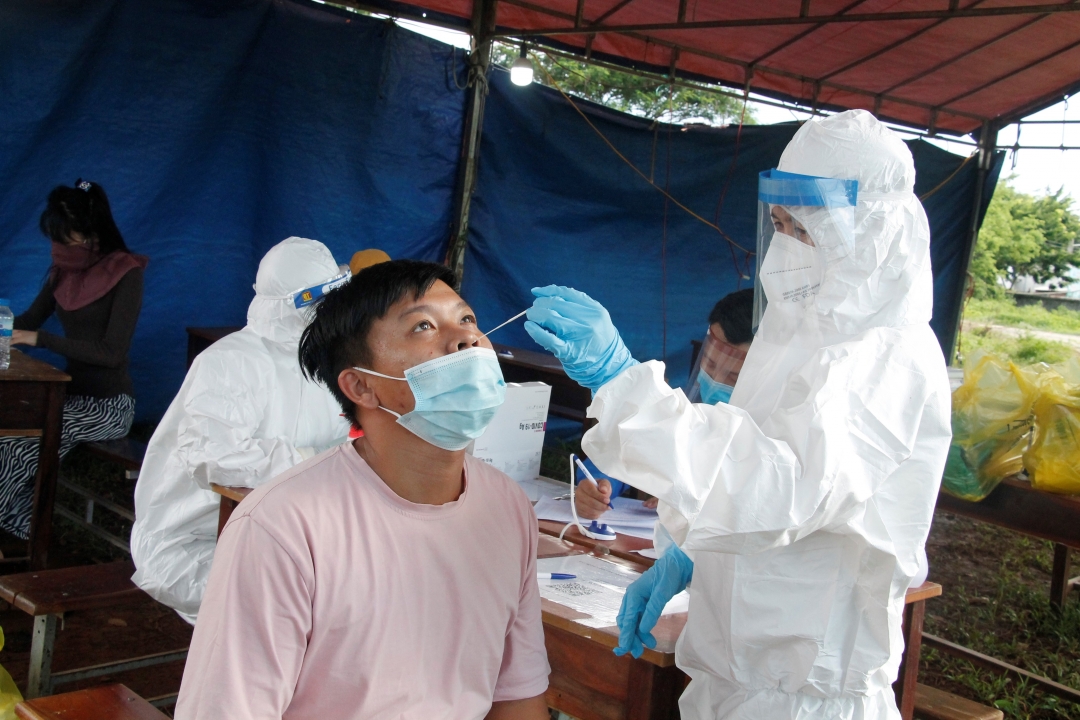 Nhân viên y tế lấy mẫu  xét nghiệm  SARS-CoV-2  cho tài xế  tại chốt kiểm soát phòng, chống dịch COVID-19  (Quốc lộ 14,  xã Hòa Phú,  TP. Buôn Ma Thuột). 