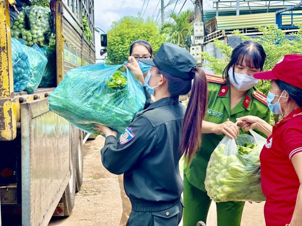 Các thành viên Hội Phụ nữ Công an tỉnh Đắk Lắk và Hội Chữ thập đỏ  TP. Buôn Ma Thuột tập kết rau xanh  để chuyển đến TP. Hồ Chí Minh.  Ảnh: Nguyễn Th