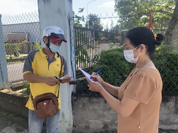 Bưu tá Nguyễn Văn Tuấn (Bưu điện huyện Lắk) giao căn cước công dân cho khách hàng.  