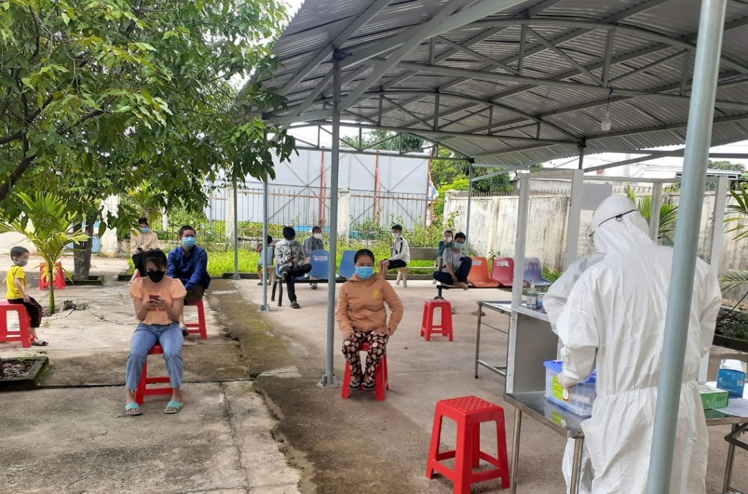 Người dân xã Cư Pui giữ khoảng cách khi ngồi chờ test nhanh.